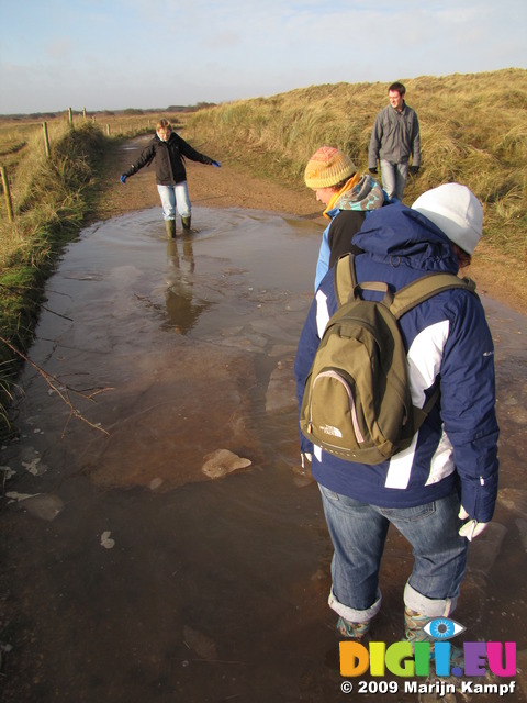 SX11265 Lib, Annie, Matt and Jenni walking through icy puddle